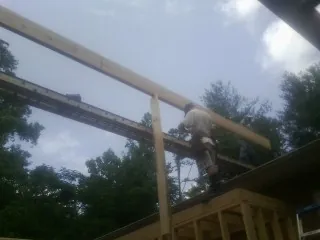 Carpenter setting a ridge beam over a new addition frame — Ice Dam Removal by Roofing Brothers in Long Prairie