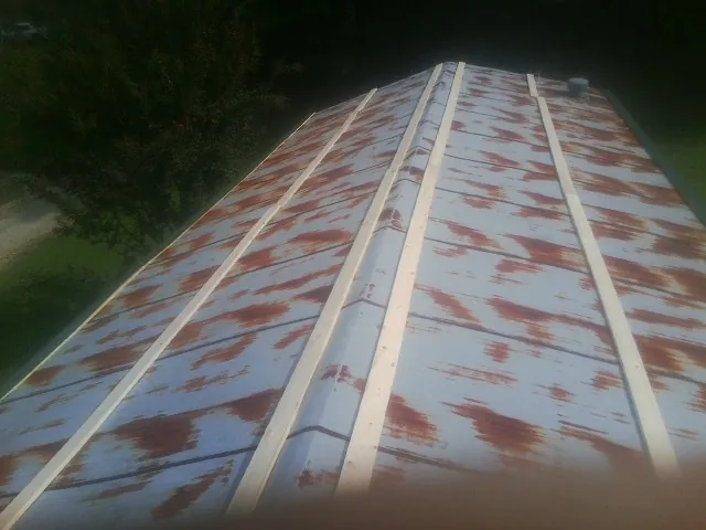 Rusted metal roof panels with new wood purlins before replacement — Storm Damage Roof Repair in Long Prairie by Roofing Brothers
