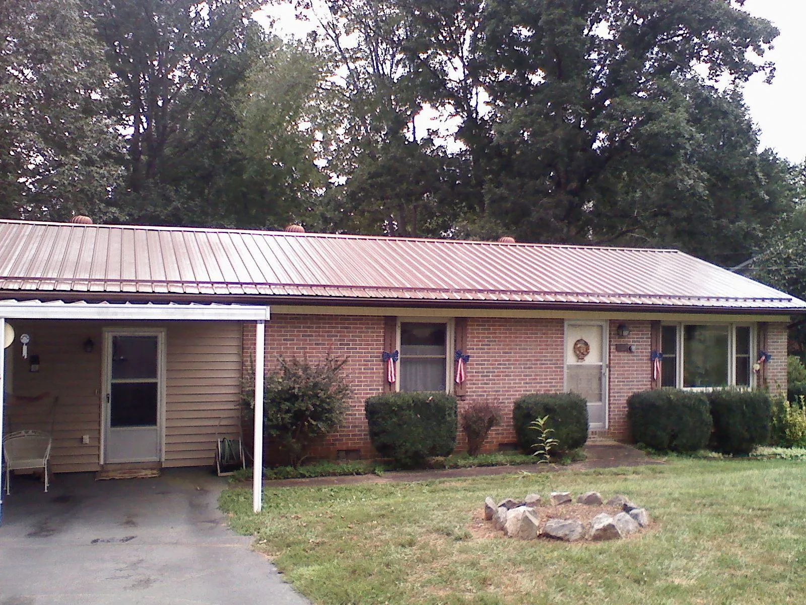 Bronze metal roof and carport on a brick ranch home — Roof Repair work by our crew in Long Prairie